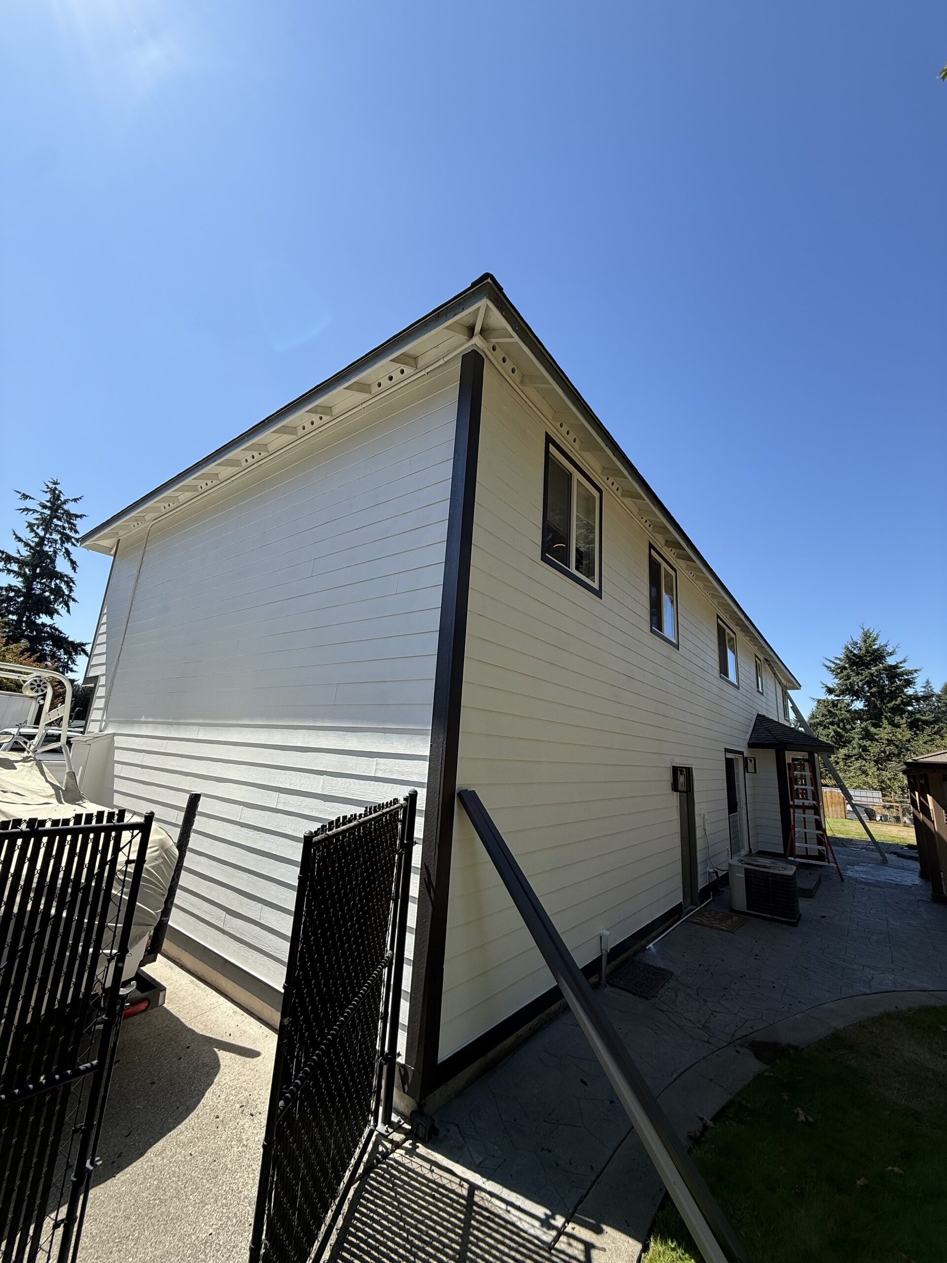 Rear elevation of a cream two-story home with dark gutters running the full fascia line